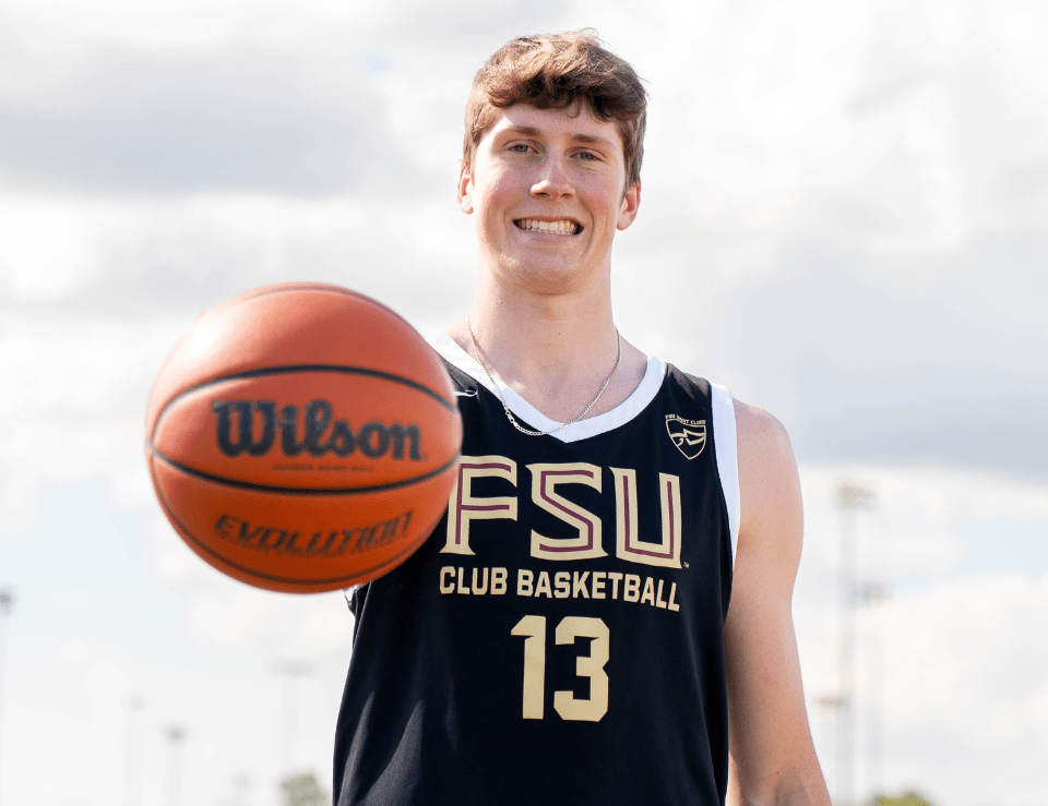 MensBasketballClub FSU Men's Club Basketball player holding a basketball in front of him posing